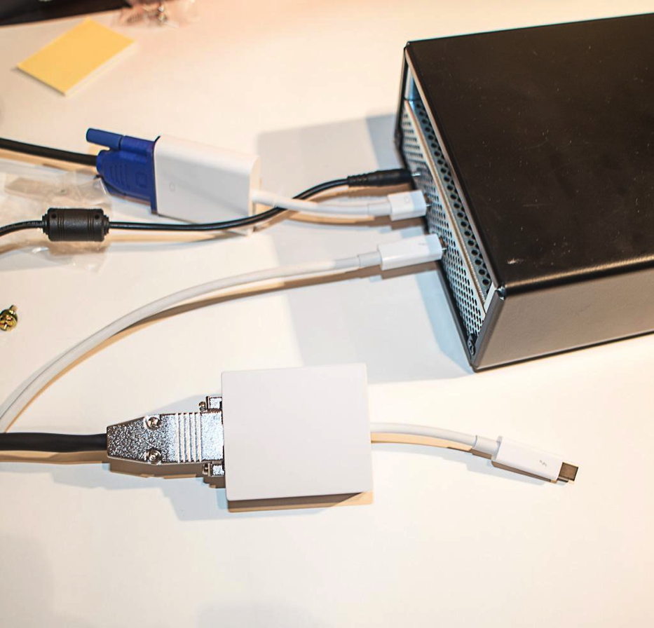 Two white video-adapter housings connected by cables to a black enclosure.