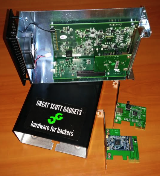 An open Thunderbolt enclosure with its circuit board and two small PCIe adapters.